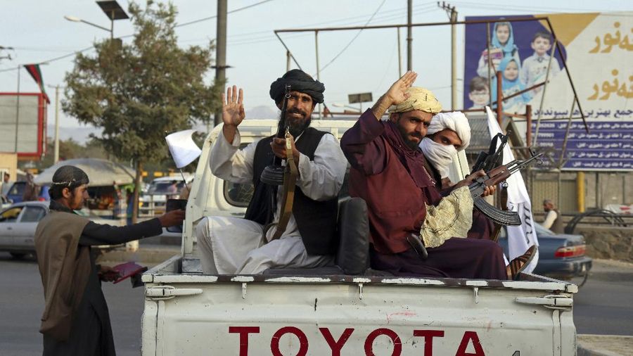 Taliban fighters hold Taliban flags in Kabul, Afghanistan, Monday, Aug. 30, 2021. Many Afghans are anxious about the Taliban rule and are figuring out ways to get out of Afghanistan. But it's the financial desperation that seems to hang heavy over the city. (AP Photo/Khwaja Tawfiq Sediqi)