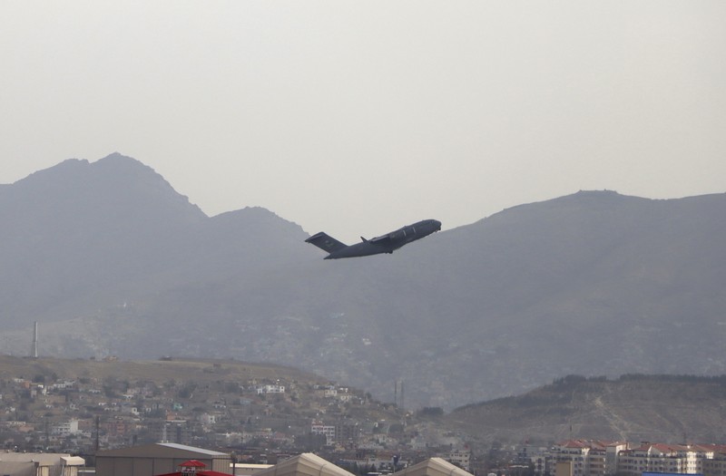 Taliban fighters hold Taliban flags in Kabul, Afghanistan, Monday, Aug. 30, 2021. Many Afghans are anxious about the Taliban rule and are figuring out ways to get out of Afghanistan. But it's the financial desperation that seems to hang heavy over the city. (AP Photo/Khwaja Tawfiq Sediqi)