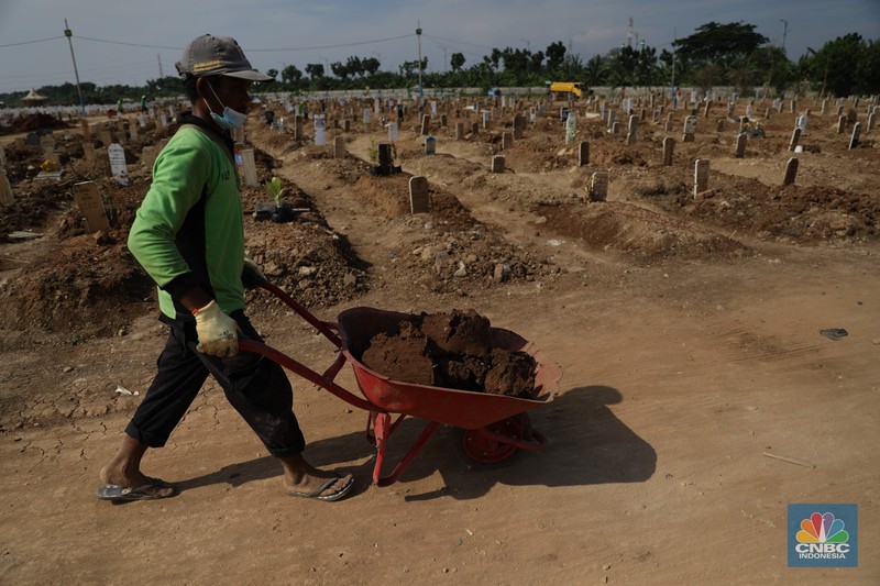 Petugas pemakaman saat melakukan perawatan tanah makam yang ambles akibat hujan di Taman Pemakaman Umum Rorotan, Jakarta Utara, Rabu (1/9/2021). Kini, setelah kasus Covid-19 mulai menurun jenazah yang datang tidak banyak. Pantauan CNBC Indonesia hingga pukul sejak pukul 13.00 hingga 16.00 tidak ada prosesi pemakaman Covid-19. Salah satu petugas Kepala  Pelaksana Taman Pemakaman Umum (TPU)  mengatakan, dalam dua hari terakhir jenazah yang dimakamkan di TPU Rorotan kurang dari 10. Untuk hari ini hanya 4 jenazah yang dimakamkan di TPU Rorotan.  Selama tidak ada proses pemakaman, petugas pemakaman melalukan perawatan makam. Banyak tanah makan yang ambles akibat hujan dan jenis kayu peti yang mudah hancur. 
TPU Rorotan memiliki luas 3 hektar yang dapat menampung sekitar 7.200 petak makam baru khusus jenazah Covid-19.  (CNBC Indonesia/ Muhammad Saki)