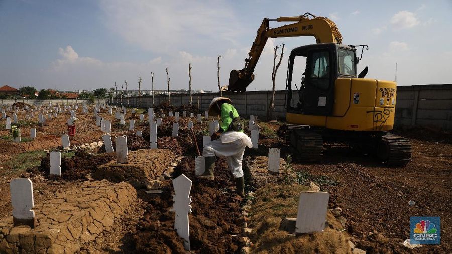 Petugas pemakaman saat melakukan perawatan tanah makam yang ambles akibat hujan di Taman Pemakaman Umum Rorotan, Jakarta Utara, Rabu (1/9/2021). Kini, setelah kasus Covid-19 mulai menurun jenazah yang datang tidak banyak. Pantauan CNBC Indonesia hingga pukul sejak pukul 13.00 hingga 16.00 tidak ada prosesi pemakaman Covid-19. Salah satu petugas Kepala  Pelaksana Taman Pemakaman Umum (TPU)  mengatakan, dalam dua hari terakhir jenazah yang dimakamkan di TPU Rorotan kurang dari 10. Untuk hari ini hanya 4 jenazah yang dimakamkan di TPU Rorotan.  Selama tidak ada proses pemakaman, petugas pemakaman melalukan perawatan makam. Banyak tanah makan yang ambles akibat hujan dan jenis kayu peti yang mudah hancur. 
TPU Rorotan memiliki luas 3 hektar yang dapat menampung sekitar 7.200 petak makam baru khusus jenazah Covid-19.  (CNBC Indonesia/ Muhammad Saki)