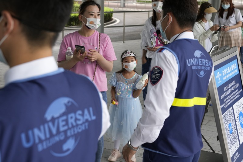 Visitors wearing masks prepare to visit the Universal Studios theme park during trial runs in Beijing, China, Tuesday, Aug. 31, 2021. Universal Studios announced Monday, Aug. 30, 2021, that its first theme park in China will open in the country's capital in September. The company set the opening date for Sept. 20, according to a statement and video posted on the Chinese social media site WeChat. (AP Photo/Ng Han Guan)