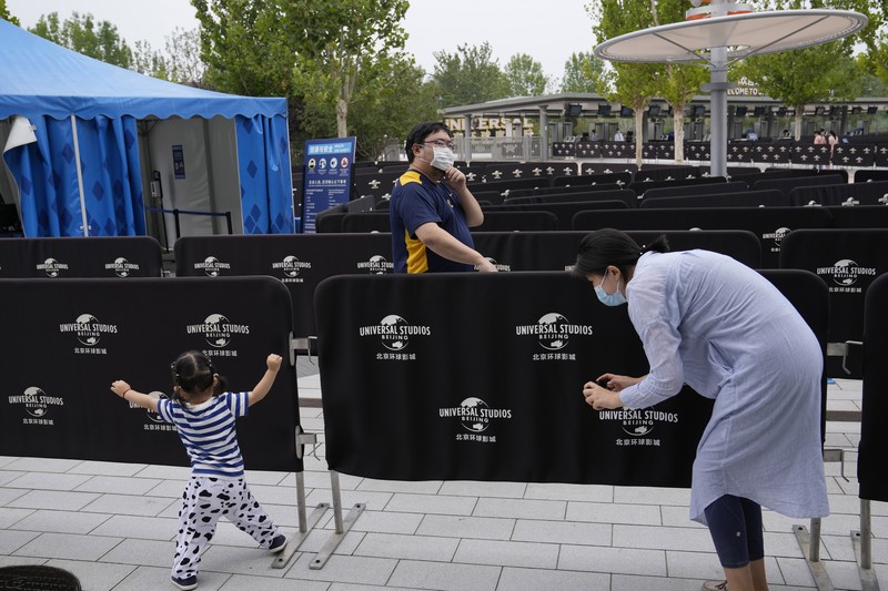 Visitors wearing masks prepare to visit the Universal Studios theme park during trial runs in Beijing, China, Tuesday, Aug. 31, 2021. Universal Studios announced Monday, Aug. 30, 2021, that its first theme park in China will open in the country's capital in September. The company set the opening date for Sept. 20, according to a statement and video posted on the Chinese social media site WeChat. (AP Photo/Ng Han Guan)