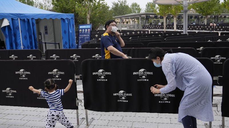 Visitors wearing masks prepare to visit the Universal Studios theme park during trial runs in Beijing, China, Tuesday, Aug. 31, 2021. Universal Studios announced Monday, Aug. 30, 2021, that its first theme park in China will open in the country's capital in September. The company set the opening date for Sept. 20, according to a statement and video posted on the Chinese social media site WeChat. (AP Photo/Ng Han Guan)