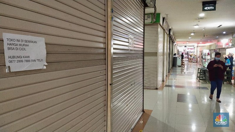 Pengunjung melewati ruko yang bertuliskan 