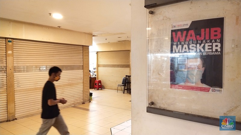 Pengunjung melewati ruko yang bertuliskan 