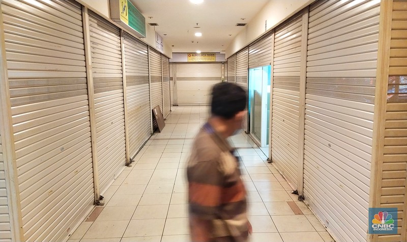 Pengunjung melewati ruko yang bertuliskan 