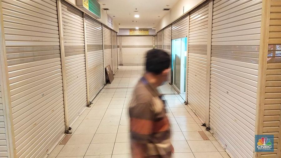 Pengunjung melewati ruko yang bertuliskan 