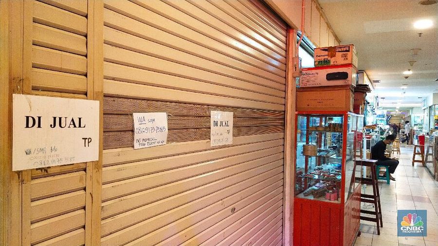 Pengunjung melewati ruko yang bertuliskan 