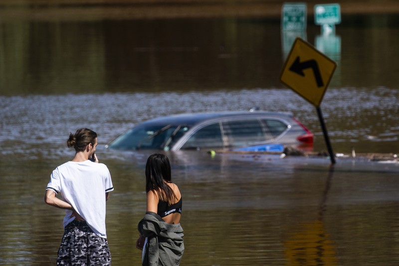 A resident of 153rd St. in the Flushing neighborhood of the Queens borough of New York sits outside her home with her water logged belongings, Thursday, Sept. 2, 2021, in New York. The remnants of Hurricane Ida dumped historic rain over New York City, with several deaths linked to flooding in the region as basement apartments suddenly filled with water and freeways and boulevards turned into rivers, submerging cars.(AP Photo/Mary Altaffer)