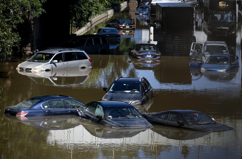 A resident of 153rd St. in the Flushing neighborhood of the Queens borough of New York sits outside her home with her water logged belongings, Thursday, Sept. 2, 2021, in New York. The remnants of Hurricane Ida dumped historic rain over New York City, with several deaths linked to flooding in the region as basement apartments suddenly filled with water and freeways and boulevards turned into rivers, submerging cars.(AP Photo/Mary Altaffer)