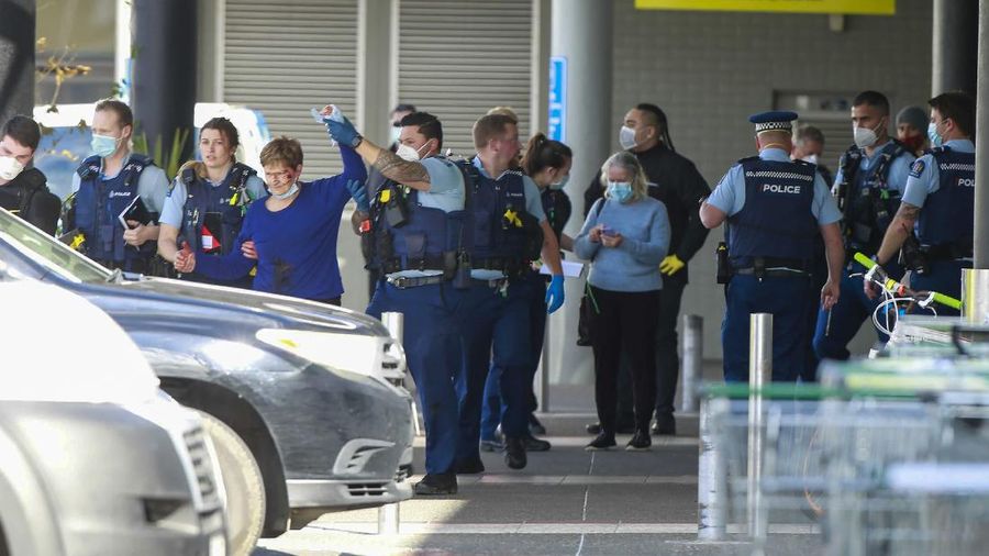 A police officer stands outside an Auckland supermarket, Friday, Sept. 3, 2021. New Zealand authorities said Friday they shot and killed a violent extremist after he entered a supermarket and stabbed and injured several shoppers. Prime Minister Jacinda Ardern described the incident as a terror attack. (Alex Burton/New Zealand Herald via AP)