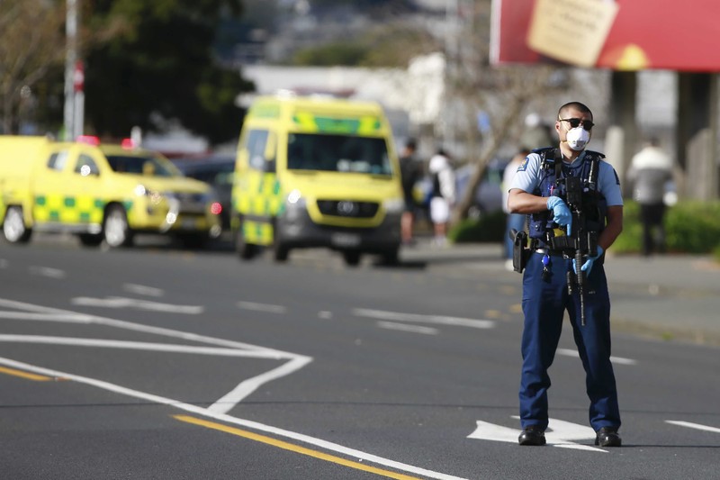 A police officer stands outside an Auckland supermarket, Friday, Sept. 3, 2021. New Zealand authorities said Friday they shot and killed a violent extremist after he entered a supermarket and stabbed and injured several shoppers. Prime Minister Jacinda Ardern described the incident as a terror attack. (Alex Burton/New Zealand Herald via AP)