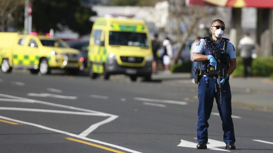 A police officer stands outside an Auckland supermarket, Friday, Sept. 3, 2021. New Zealand authorities said Friday they shot and killed a violent extremist after he entered a supermarket and stabbed and injured several shoppers. Prime Minister Jacinda Ardern described the incident as a terror attack. (Alex Burton/New Zealand Herald via AP)