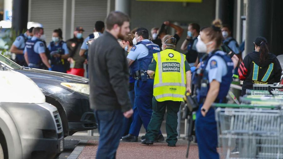 A police officer stands outside an Auckland supermarket, Friday, Sept. 3, 2021. New Zealand authorities said Friday they shot and killed a violent extremist after he entered a supermarket and stabbed and injured several shoppers. Prime Minister Jacinda Ardern described the incident as a terror attack. (Alex Burton/New Zealand Herald via AP)