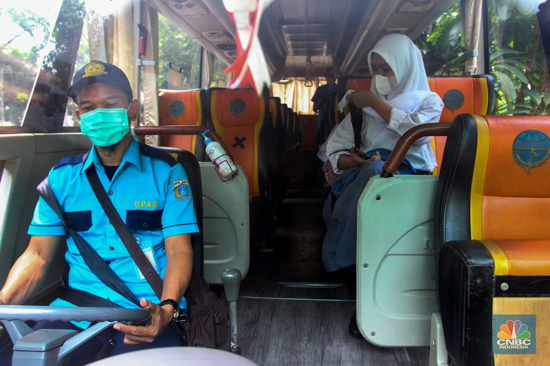 Sejumlah pelajar menaiki bus sekolah usai mengikuti pembelajaran tatap muka (PTM) di SMK Negeri 15, Kebayoran Baru, Jakarta Selatan, Jumat (3/9). Dinas Perhubungan DKI Jakarta melalui Unit Pengelola (UP) Angkutan Sekolah membantu sarana transportasi gratis bagi peserta didik yang mengikuti PTM secara terbatas dengan mengoperasikan 70 bus sekolah yang melayani 20 rute reguler dan 13 rute zonasi. Sebelum digunakan bus sekolah yang layani antar dan jemput pelajar juga terlebih dahulu disemprot cairan disinfektan. Pelajar yang akan menggunakan layanan antar dan jemput bus sekolah juga wajib menerapkan protokol kesehatan dengan menggunakan masker dan menjaga jarak saat berada di dalam bus. (CNBC Indonesia/ Muhammad Sabki)