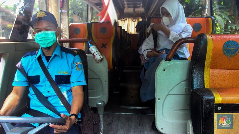 Sejumlah pelajar menaiki bus sekolah usai mengikuti pembelajaran tatap muka (PTM) di SMK Negeri 15, Kebayoran Baru, Jakarta Selatan, Jumat (3/9). Dinas Perhubungan DKI Jakarta melalui Unit Pengelola (UP) Angkutan Sekolah membantu sarana transportasi gratis bagi peserta didik yang mengikuti PTM secara terbatas dengan mengoperasikan 70 bus sekolah yang melayani 20 rute reguler dan 13 rute zonasi. Sebelum digunakan bus sekolah yang layani antar dan jemput pelajar juga terlebih dahulu disemprot cairan disinfektan. Pelajar yang akan menggunakan layanan antar dan jemput bus sekolah juga wajib menerapkan protokol kesehatan dengan menggunakan masker dan menjaga jarak saat berada di dalam bus. (CNBC Indonesia/ Muhammad Sabki)
