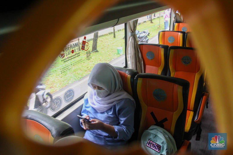PTM Dimulai, Bus Sekolah Kembali antar Jemput Siswa Sejumlah pelajar menaiki bus sekolah usai mengikuti pembelajaran tatap muka (PTM) di SMK Negeri 15, Kebayoran Baru, Jakarta Selatan, Jumat (3/9). Dinas Perhubungan DKI Jakarta melalui Unit Pengelola (UP) Angkutan Sekolah membantu sarana transportasi gratis bagi peserta didik yang mengikuti PTM secara terbatas dengan mengoperasikan 70 bus sekolah yang melayani 20 rute reguler dan 13 rute zonasi. Sebelum digunakan bus sekolah yang layani antar dan jemput pelajar juga terlebih dahulu disemprot cairan disinfektan. Pelajar yang akan menggunakan layanan antar dan jemput bus sekolah juga wajib menerapkan protokol kesehatan dengan menggunakan masker dan menjaga jarak saat berada di dalam bus. (CNBC Indonesia/ Muhammad Sabki)
