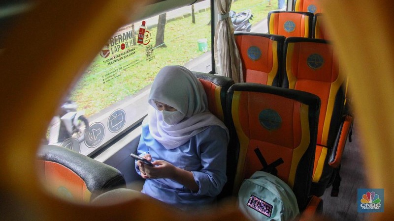 Sejumlah pelajar menaiki bus sekolah usai mengikuti pembelajaran tatap muka (PTM) di SMK Negeri 15, Kebayoran Baru, Jakarta Selatan, Jumat (3/9). Dinas Perhubungan DKI Jakarta melalui Unit Pengelola (UP) Angkutan Sekolah membantu sarana transportasi gratis bagi peserta didik yang mengikuti PTM secara terbatas dengan mengoperasikan 70 bus sekolah yang melayani 20 rute reguler dan 13 rute zonasi. Sebelum digunakan bus sekolah yang layani antar dan jemput pelajar juga terlebih dahulu disemprot cairan disinfektan. Pelajar yang akan menggunakan layanan antar dan jemput bus sekolah juga wajib menerapkan protokol kesehatan dengan menggunakan masker dan menjaga jarak saat berada di dalam bus. (CNBC Indonesia/ Muhammad Sabki)