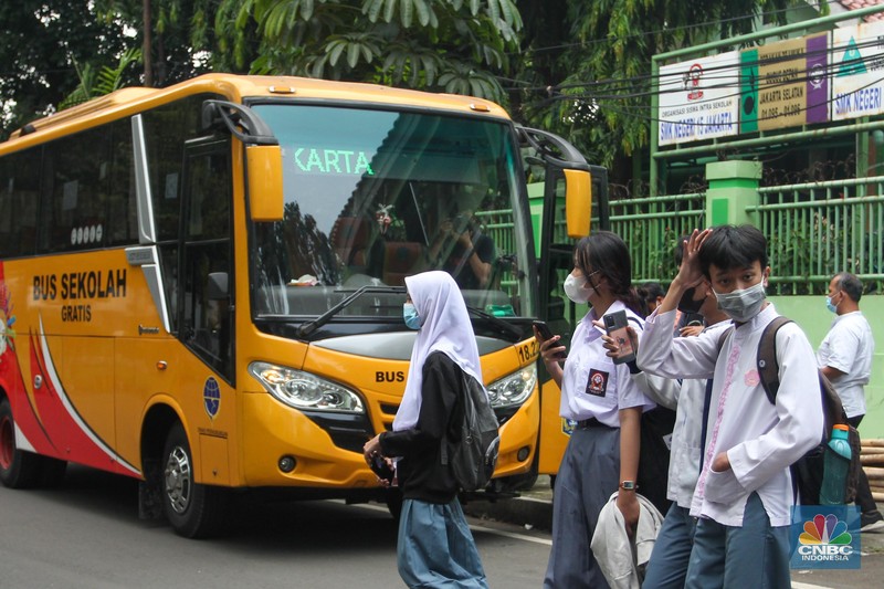 Sejumlah pelajar menaiki bus sekolah usai mengikuti pembelajaran tatap muka (PTM) di SMK Negeri 15, Kebayoran Baru, Jakarta Selatan, Jumat (3/9). Dinas Perhubungan DKI Jakarta melalui Unit Pengelola (UP) Angkutan Sekolah membantu sarana transportasi gratis bagi peserta didik yang mengikuti PTM secara terbatas dengan mengoperasikan 70 bus sekolah yang melayani 20 rute reguler dan 13 rute zonasi. Sebelum digunakan bus sekolah yang layani antar dan jemput pelajar juga terlebih dahulu disemprot cairan disinfektan. Pelajar yang akan menggunakan layanan antar dan jemput bus sekolah juga wajib menerapkan protokol kesehatan dengan menggunakan masker dan menjaga jarak saat berada di dalam bus. (CNBC Indonesia/ Muhammad Sabki)
