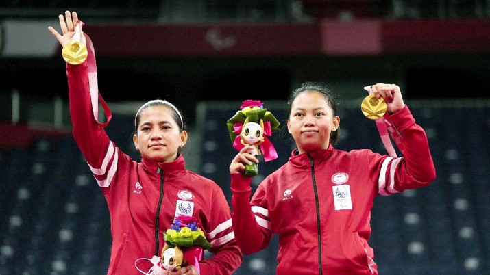 Atlet Indonesia Oktila Leani Ratri (kiri) dan Sadiyah Khalimatus berpose dengan medali emas saat penyerahan medali emas ganda putri kategori SL3-SU5 pada Paralympic Games Tokyo 2020, Sabtu, (4/9/2021) di Tokyo, Jepang. (AP/Yohei Nishimura)