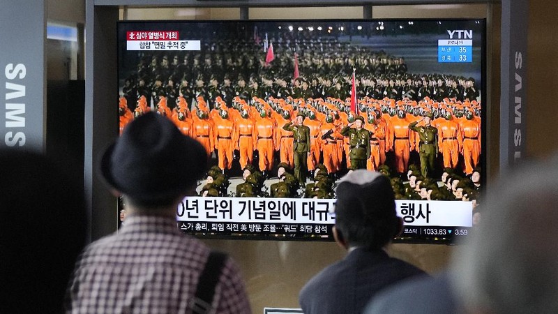 Parade militer besar-besaran Korut yang terbaru menampilkan barisan personel yang memakai baju hazmat warna oranye. (via REUTERS/KCNA)