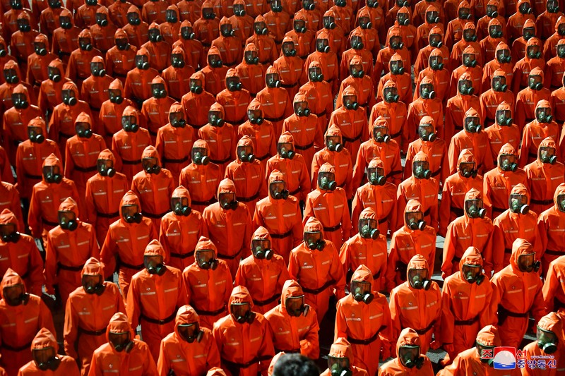 Parade militer besar-besaran Korut yang terbaru menampilkan barisan personel yang memakai baju hazmat warna oranye. (via REUTERS/KCNA) Parade militer besar-besaran Korut yang terbaru menampilkan barisan personel yang memakai baju hazmat warna oranye. (via REUTERS/KCNA)