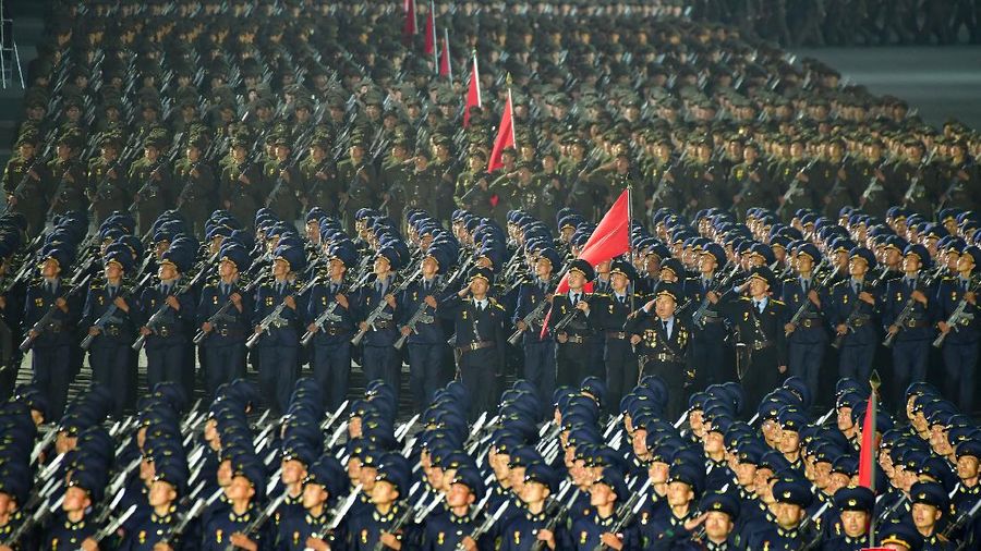 Parade militer besar-besaran Korut yang terbaru menampilkan barisan personel yang memakai baju hazmat warna oranye. (via REUTERS/KCNA)