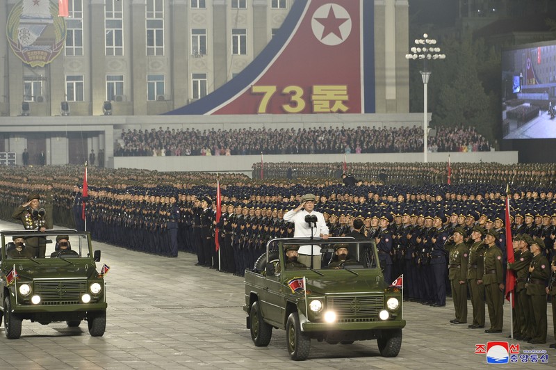 Parade militer besar-besaran Korut yang terbaru menampilkan barisan personel yang memakai baju hazmat warna oranye. (via REUTERS/KCNA) Parade militer besar-besaran Korut yang terbaru menampilkan barisan personel yang memakai baju hazmat warna oranye. (via REUTERS/KCNA)