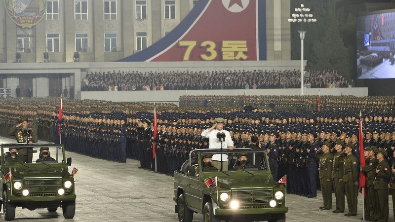 Parade militer besar-besaran Korut yang terbaru menampilkan barisan personel yang memakai baju hazmat warna oranye. (via REUTERS/KCNA)
