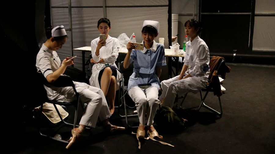 A model waits backstage before a fashion show with creations for medical professionals, designed by the Beijing Institute of Fashion Technology in collaboration with Dishang, during China Fashion Week in Beijing, China September 11, 2021. REUTERS/Tingshu Wang