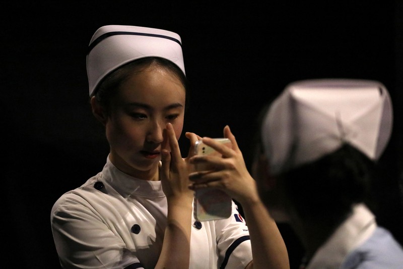 China Fashion Week Busana Medis A model waits backstage before a fashion show with creations for medical professionals, designed by the Beijing Institute of Fashion Technology in collaboration with Dishang, during China Fashion Week in Beijing, China September 11, 2021. REUTERS/Tingshu Wang