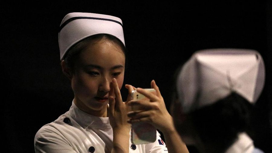 A model waits backstage before a fashion show with creations for medical professionals, designed by the Beijing Institute of Fashion Technology in collaboration with Dishang, during China Fashion Week in Beijing, China September 11, 2021. REUTERS/Tingshu Wang