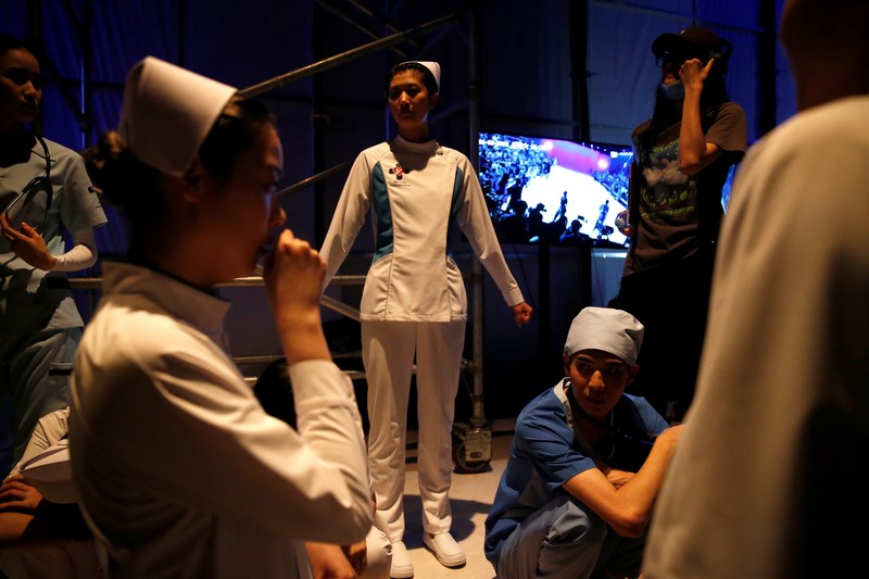 China Fashion Week Busana Medis A model waits backstage before a fashion show with creations for medical professionals, designed by the Beijing Institute of Fashion Technology in collaboration with Dishang, during China Fashion Week in Beijing, China September 11, 2021. REUTERS/Tingshu Wang