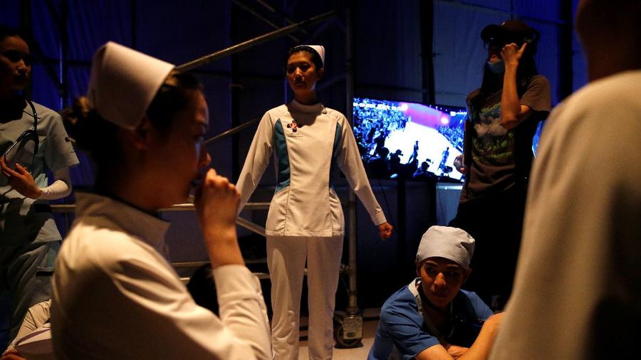 A model waits backstage before a fashion show with creations for medical professionals, designed by the Beijing Institute of Fashion Technology in collaboration with Dishang, during China Fashion Week in Beijing, China September 11, 2021. REUTERS/Tingshu Wang