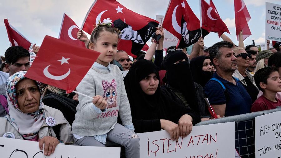 A demonstrator holds a placard reading 