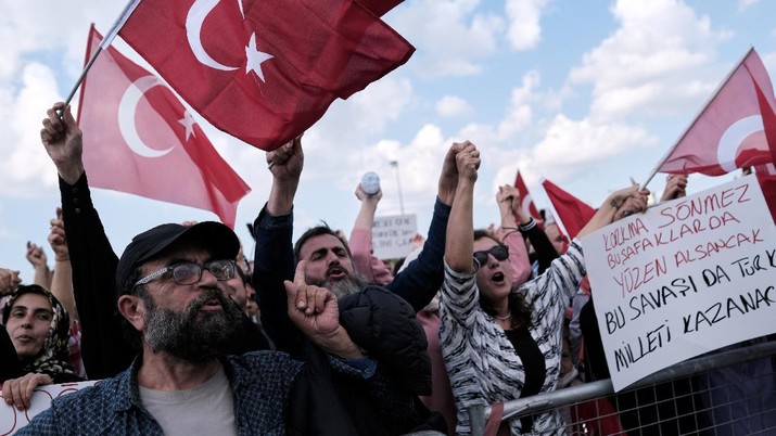 Demonstrators wave Turkish flags as they shout slogans during a protest against official coronavirus disease (COVID-19)-related mandates, including vaccinations, tests and masks, in Istanbul, Turkey September 11, 2021. REUTERS/Murad Sezer