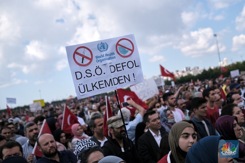 Demo Turki terkait penolakan kewajiban vaksinasi A demonstrator holds a placard reading