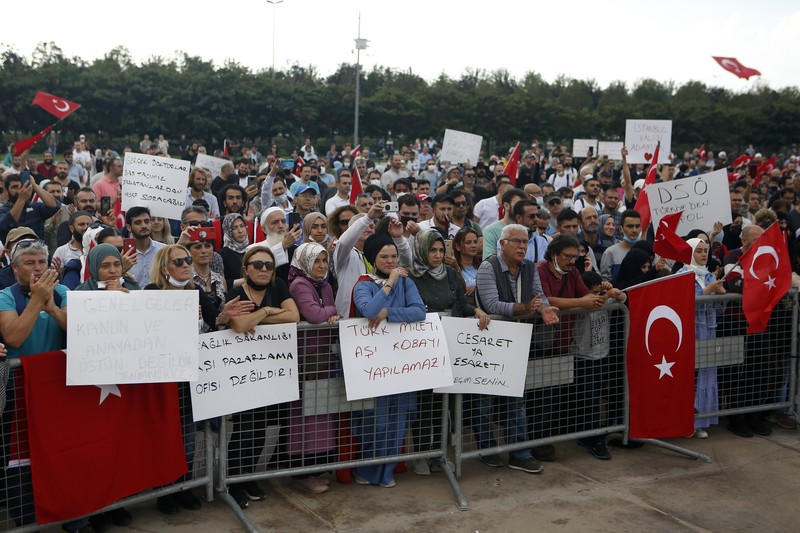 Demo Turki terkait penolakan kewajiban vaksinasi A demonstrator holds a placard reading