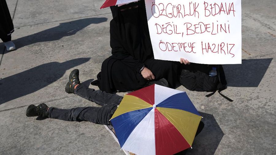 A demonstrator holds a placard reading 
