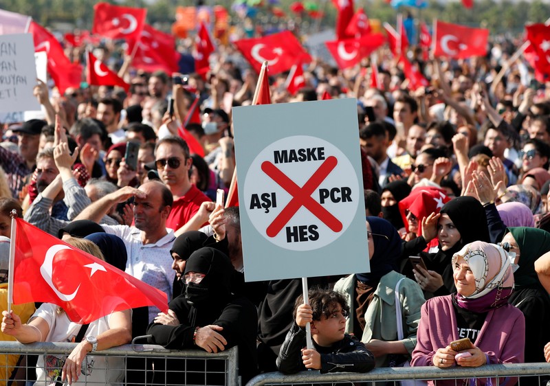 Demo Turki terkait penolakan kewajiban vaksinasi A demonstrator holds a placard reading