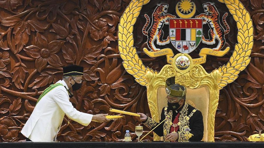 In this photo released by Malaysia's Department of Information, Malaysia's King Sultan Abdullah Sultan Ahmad Shah, right, receives documents from Prime Minister Ismail Sabri Yaakob during the opening ceremony of the parliamentary session at the parliament house in Kuala Lumpur, Malaysia, Monday, Sept. 13, 2021. Barely a month in office, Malaysia's new leader has won opposition support to shore up his fragile government in exchange for a slew of reforms as Parliament reopened Monday. (Nazri Rapaai/Malaysia's Department of Information via AP)