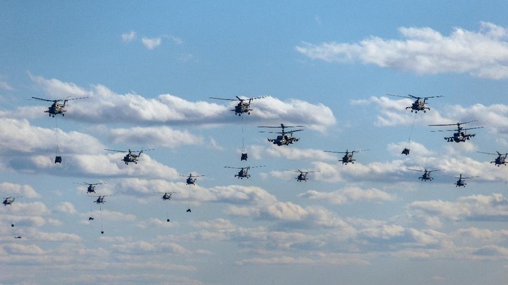 Military helicopters fly in formation above the Mulino training ground during the active phase of the military exercises 