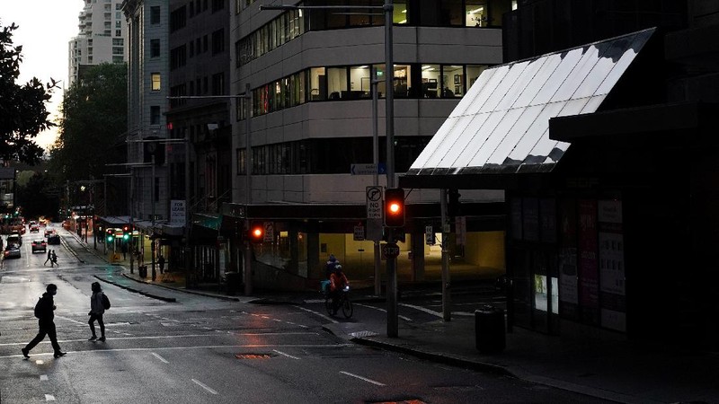 A pedestrian crosses a street at sunset in the city centre during a lockdown to curb the spread of a coronavirus disease (COVID-19) outbreak in Sydney, Australia, September 14, 2021.  REUTERS/Loren Elliott     TPX IMAGES OF THE DAY