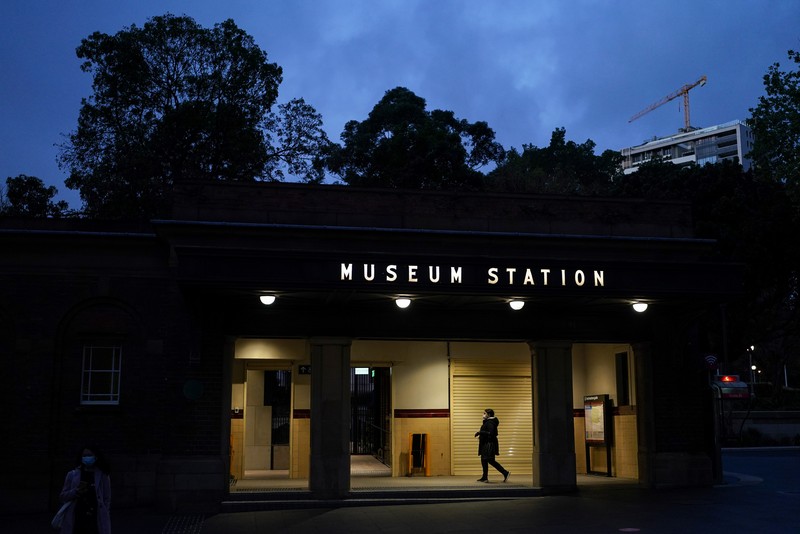 HEALTH-CORONAVIRUS/AUSTRALIA A pedestrian crosses a street at sunset in the city centre during a lockdown to curb the spread of a coronavirus disease (COVID-19) outbreak in Sydney, Australia, September 14, 2021. REUTERS/Loren Elliott TPX IMAGES OF THE DAY
