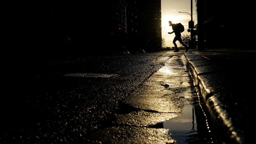A pedestrian crosses a street at sunset in the city centre during a lockdown to curb the spread of a coronavirus disease (COVID-19) outbreak in Sydney, Australia, September 14, 2021.  REUTERS/Loren Elliott     TPX IMAGES OF THE DAY
