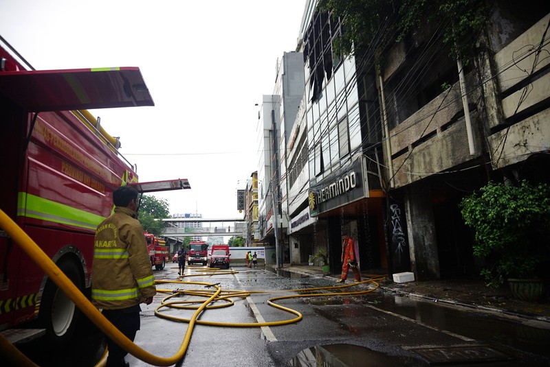 Petugas kebakaran masih berupaya memadamkan api didalam ruko yang terbakar di depan LTC Glodok, Jakarta, Selasa (14/9/2021) Ada 26 unit mobil kebakaran yang dikerahkan dilokasi kebakaran. Pantauan dilokasi api sudah berhasil dipadamkan.  (CNBC Indonesia/Tri Susilo)