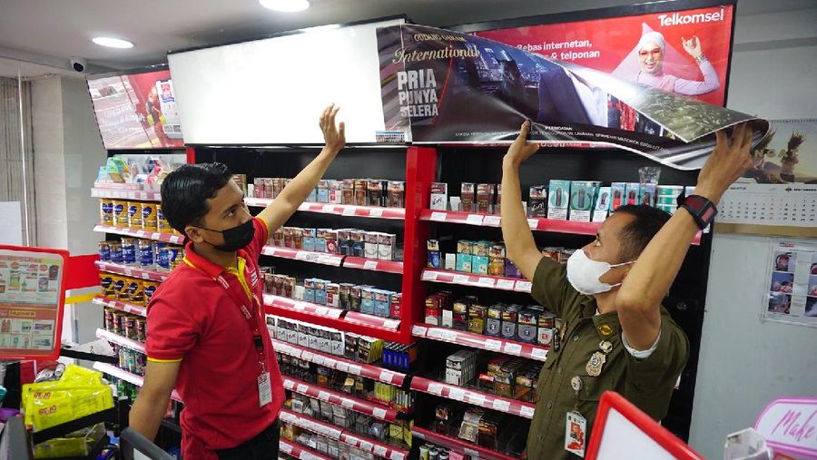 Petugas Satpol PP Jakarta Barat menutup gerai minimarket yang menjual rokok di Alfamart, Jakarta Barat, Selasa (14/9/2021). (CNBC Indonesia/Tri Susilo)