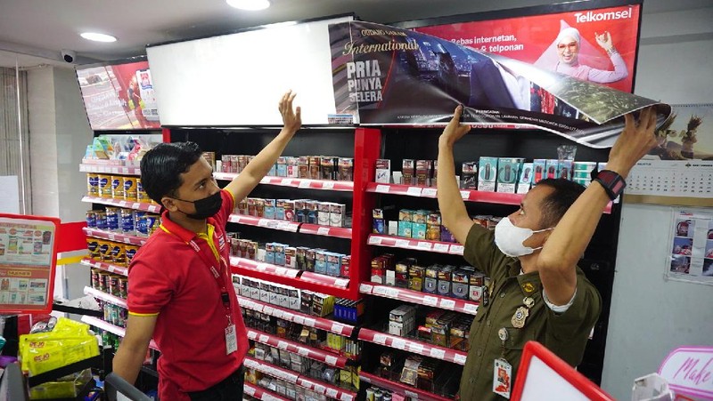 Petugas Satpol PP Jakarta Barat menutup gerai minimarket yang menjual rokok di Alfamart, Jakarta Barat, Selasa (14/9/2021). (CNBC Indonesia/Tri Susilo)