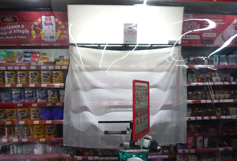 Petugas Satpol PP Jakarta Barat menutup gerai minimarket yang menjual rokok di Alfamart, Jakarta Barat, Selasa (14/9/2021). (CNBC Indonesia/Tri Susilo)