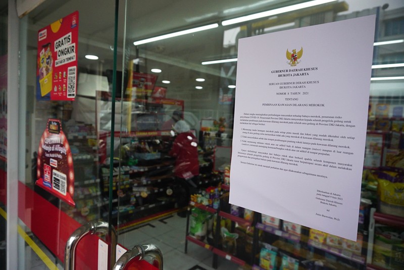 Petugas Satpol PP Jakarta Barat menutup gerai minimarket yang menjual rokok di Alfamart, Jakarta Barat, Selasa (14/9/2021). (CNBC Indonesia/Tri Susilo)